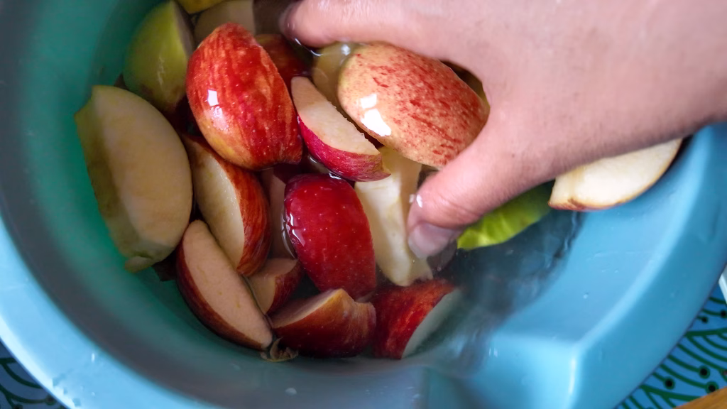 maçãs cortadas em solução de água para manter fatias de maçã na geladeira sem oxidar